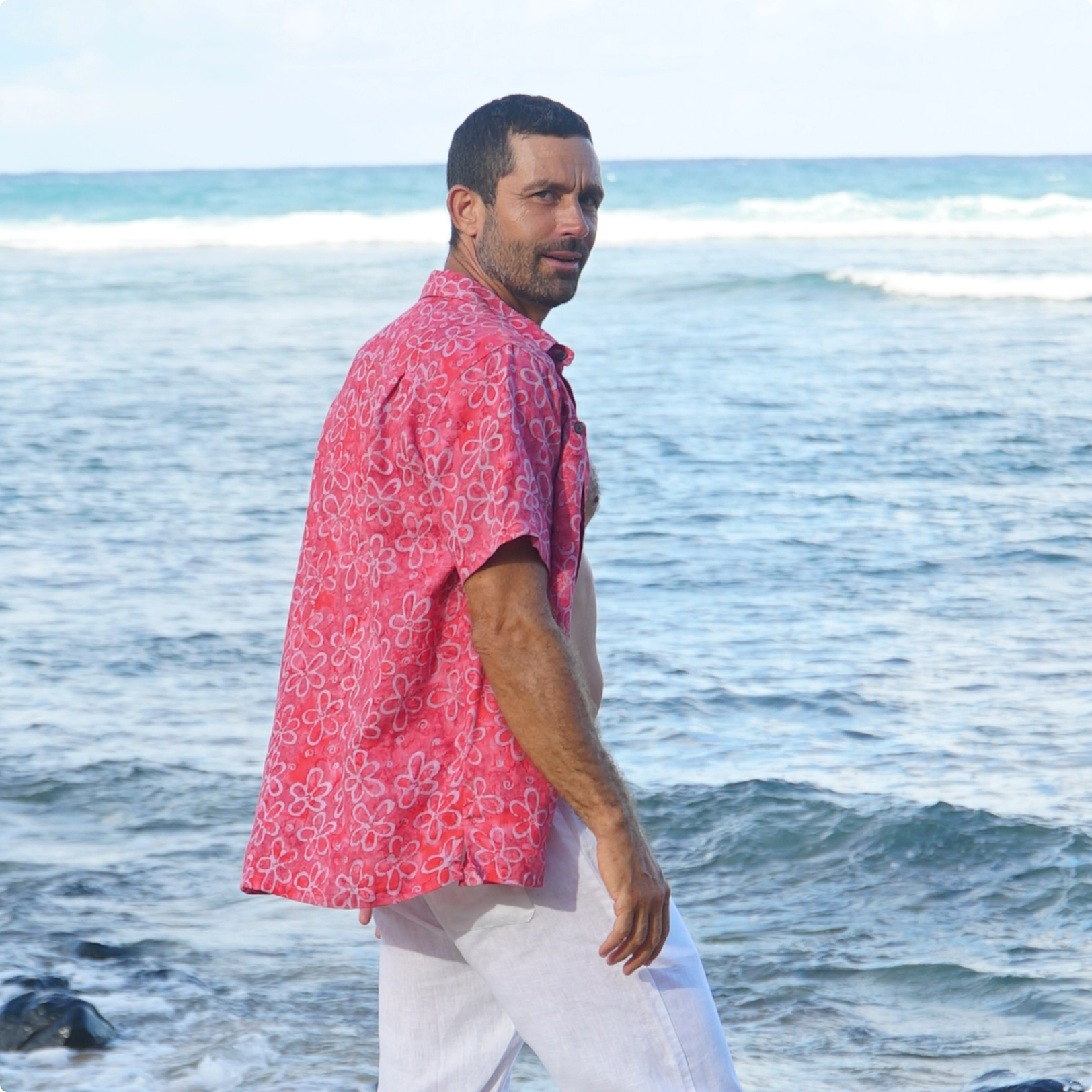 Man in pink shirt by the ocean