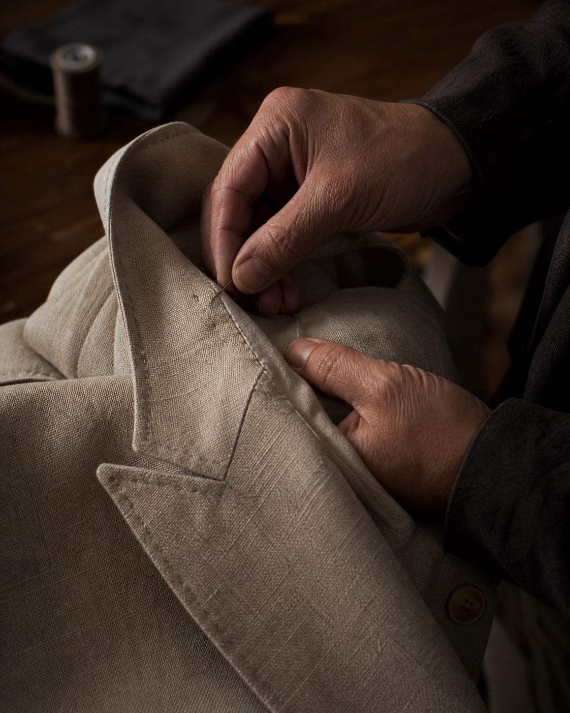 Tailor hand-finishing a linen jacket collar